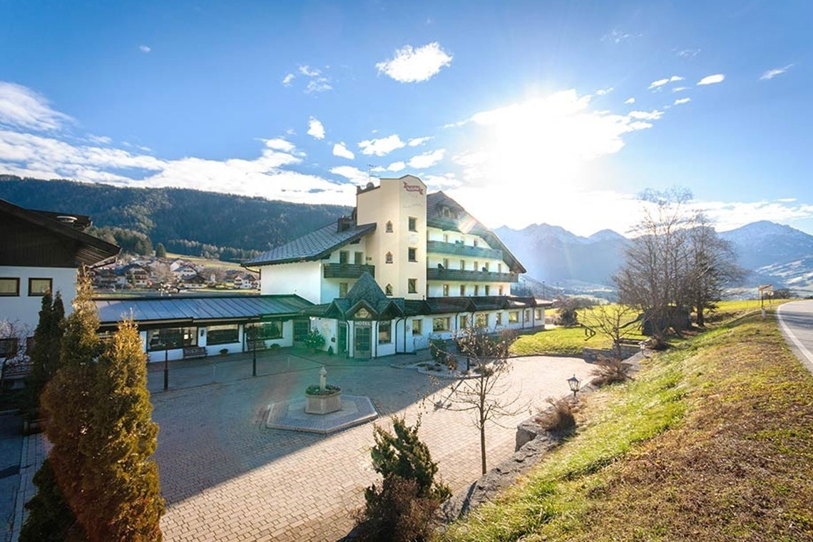 ein großes weißes Hotel mit einem Brunnen davor