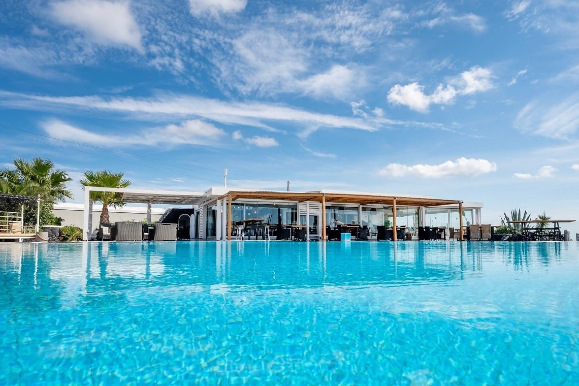 una grande piscina con un ristorante sullo sfondo