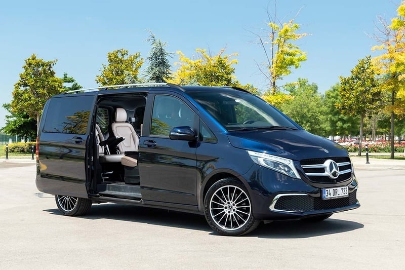 una furgoneta mercedes con las puertas abiertas está estacionada en un estacionamiento