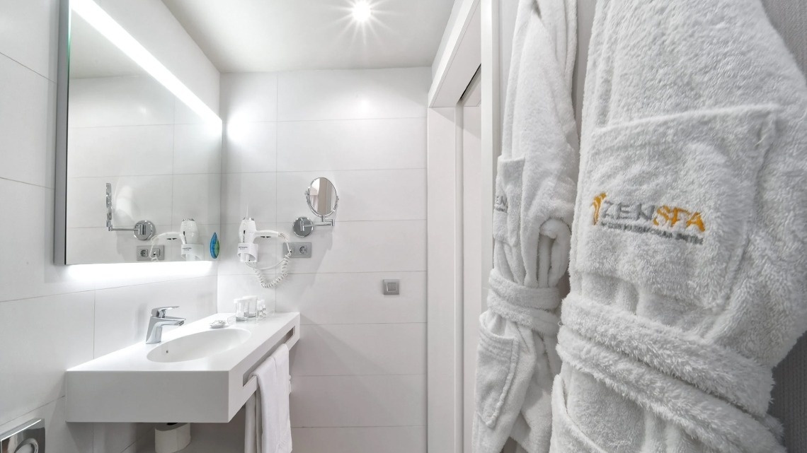 a bathroom with a sink and a towel that says zenspa