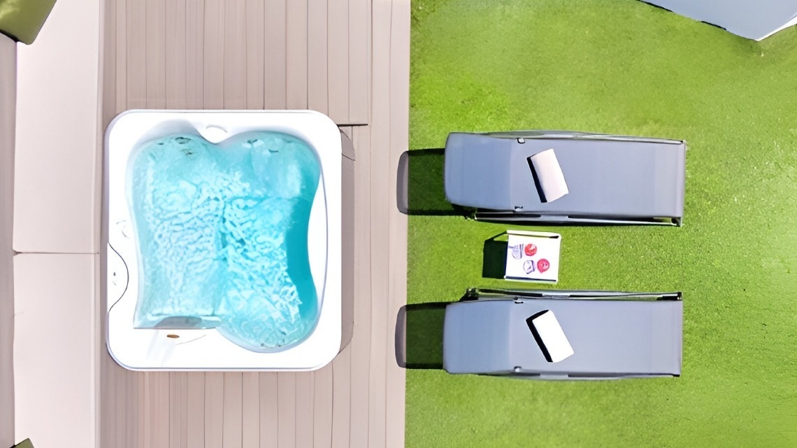 an aerial view of a hot tub and two lounge chairs