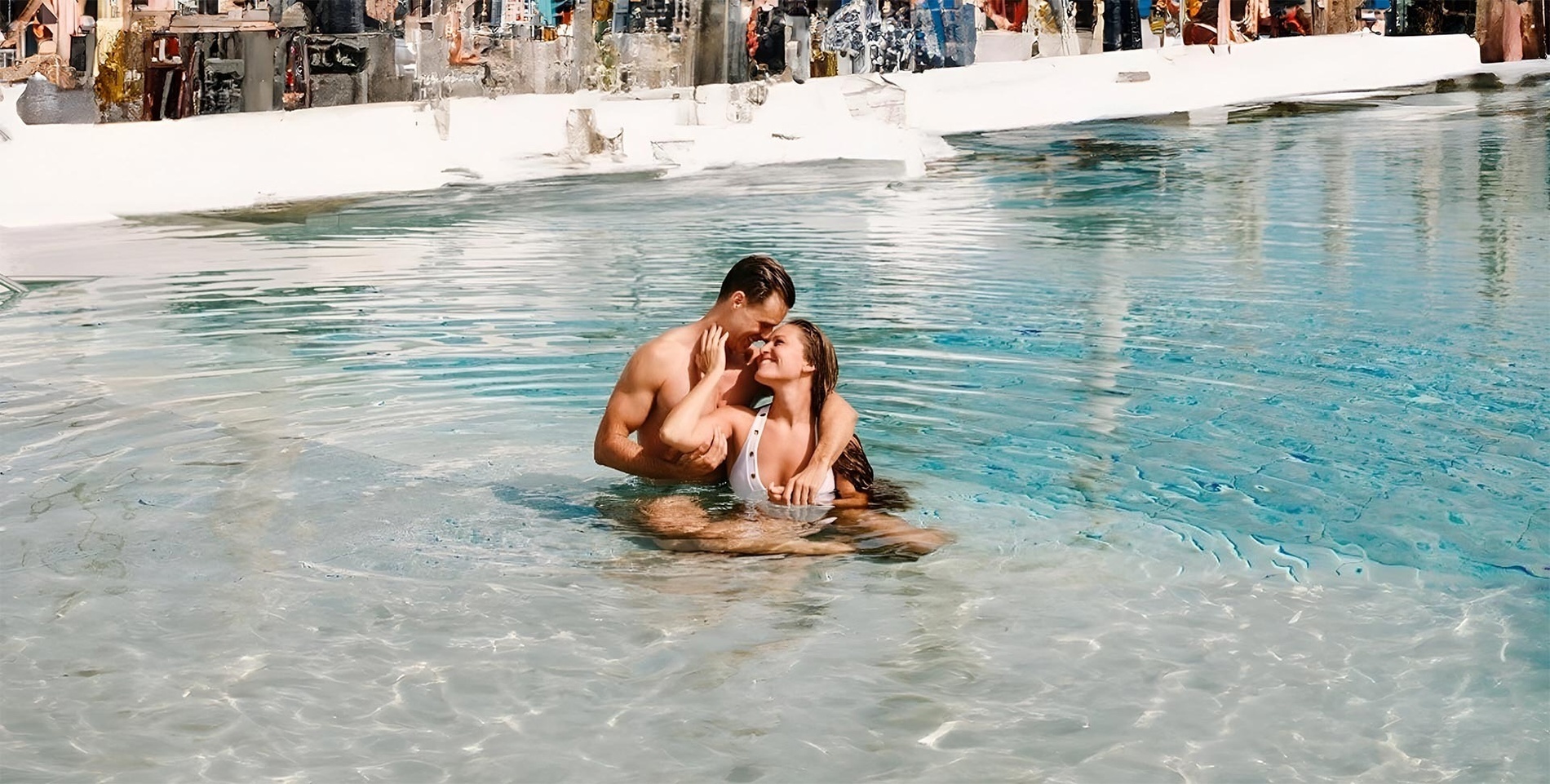 a man and woman are hugging in a swimming pool