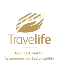 a travellife logo with a hand holding a leaf .