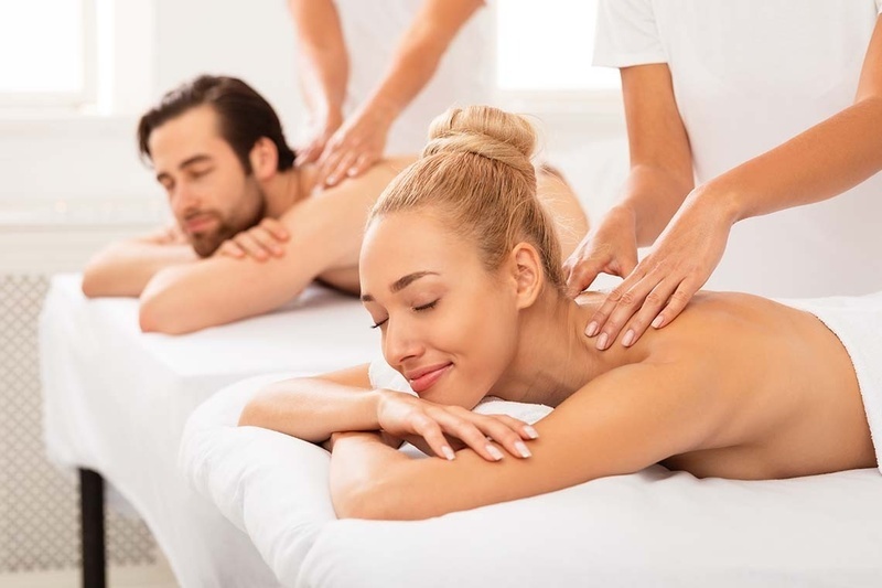 a man and a woman are getting a massage at a spa