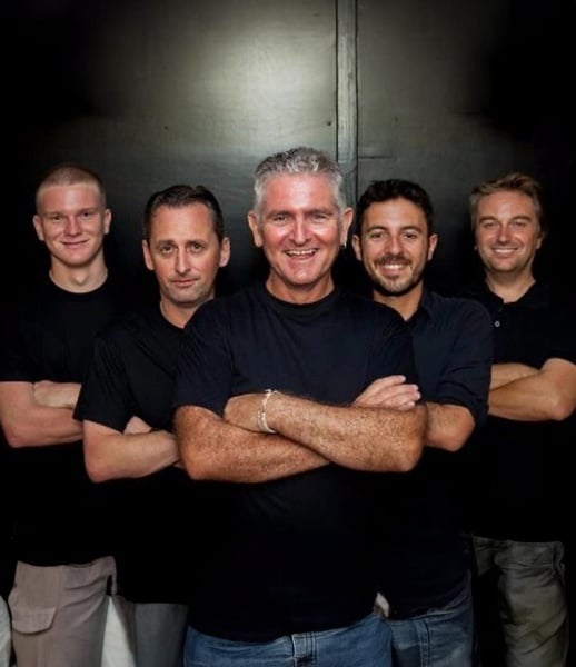 a group of men posing for a picture with their arms crossed