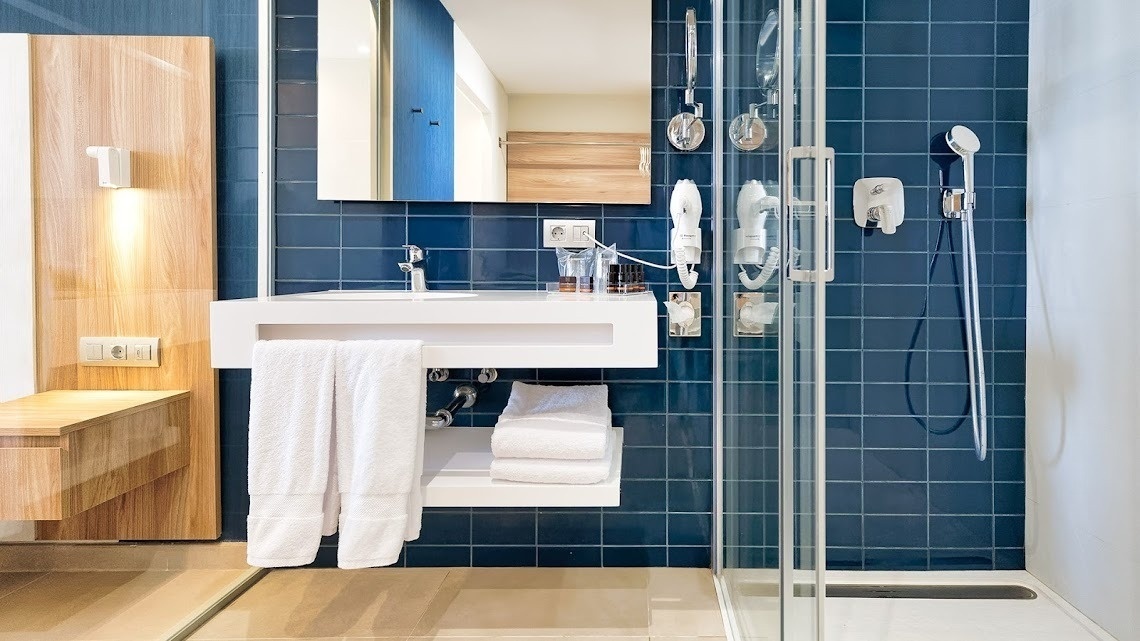 a bathroom with blue tiles and a white sink