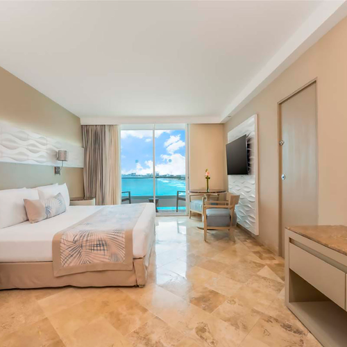 Luxury hotel room with king bed, ocean view balcony, and modern decor. DEMO 3