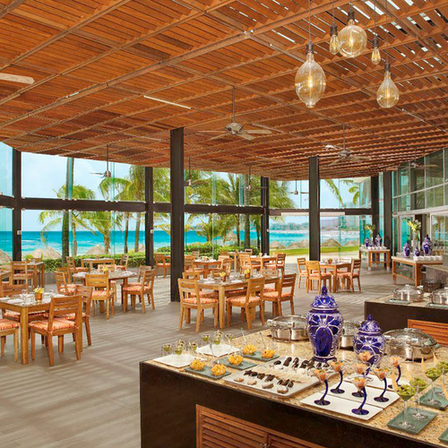 Elegant beachfront restaurant DEMO 3 with ocean views, wood ceilings, and buffet.