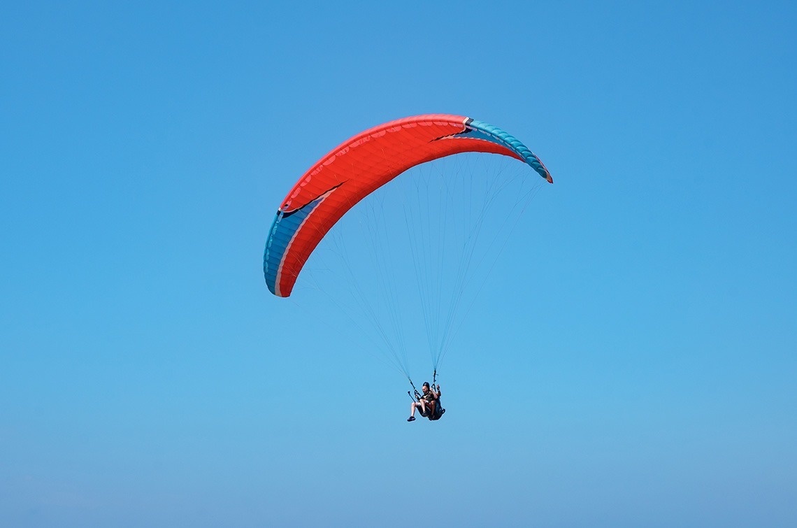 a person parasailing with a red and blue parachute