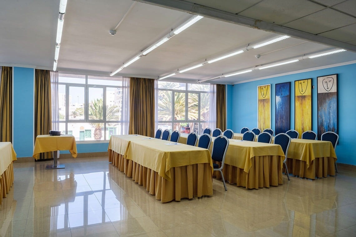 a room with tables and chairs and paintings on the wall