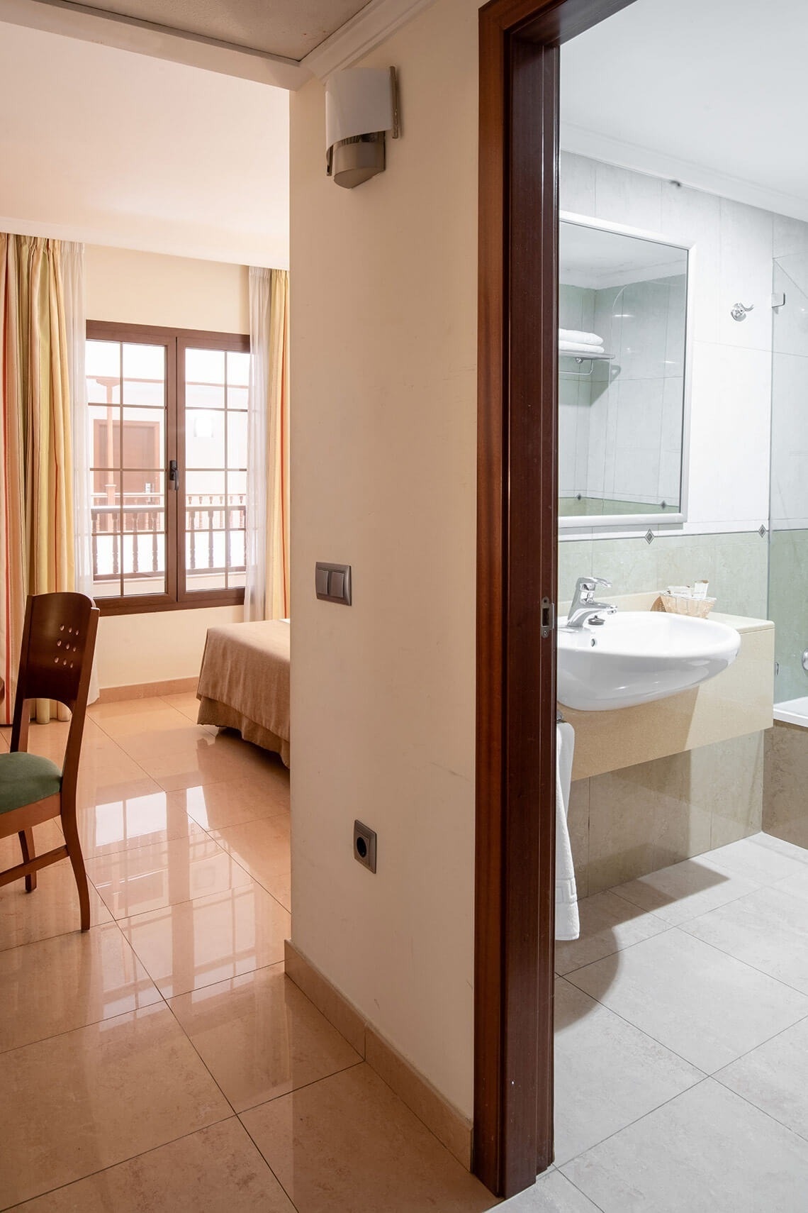 a hotel room with a sink and a chair