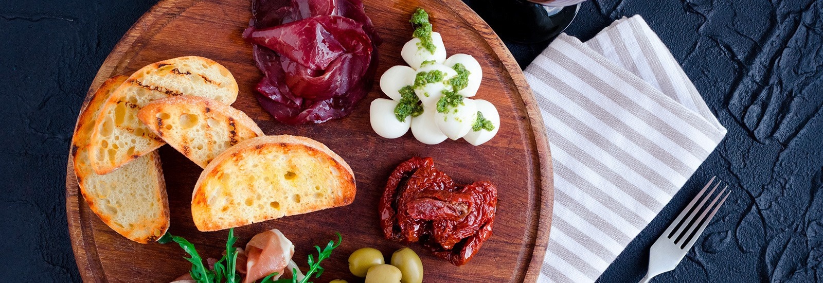 una tabla de cortar de madera con un montón de comida en ella