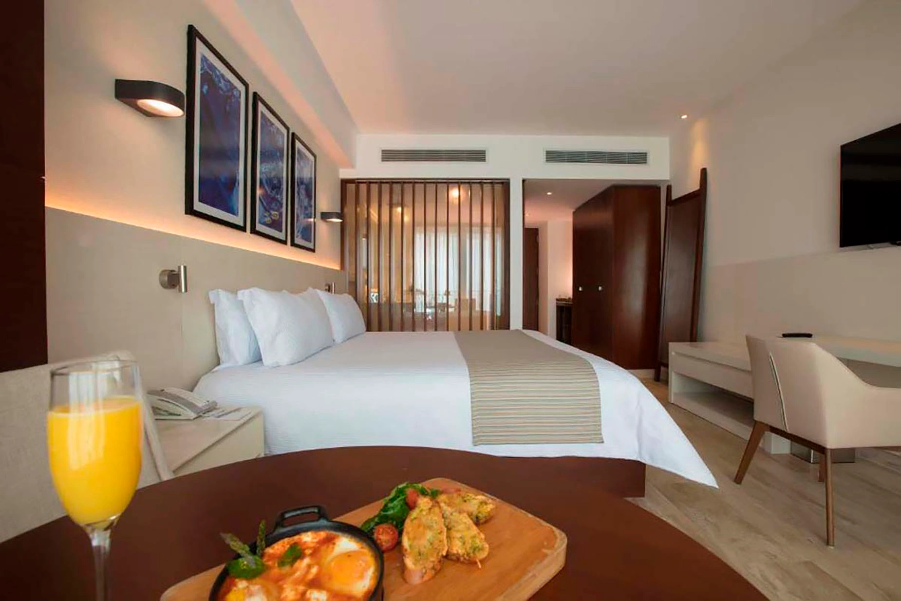 Comfortable hotel room with a king-sized bed, breakfast, and orange juice. DEMO 3
