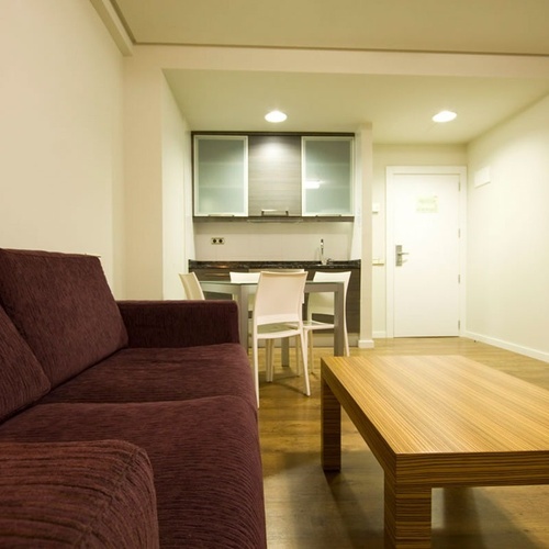 a living room with a purple couch and a wooden table