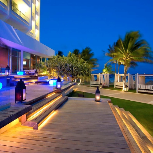 Luxury resort patio with glowing blue lights, palm trees, and cabanas. DEMO 3