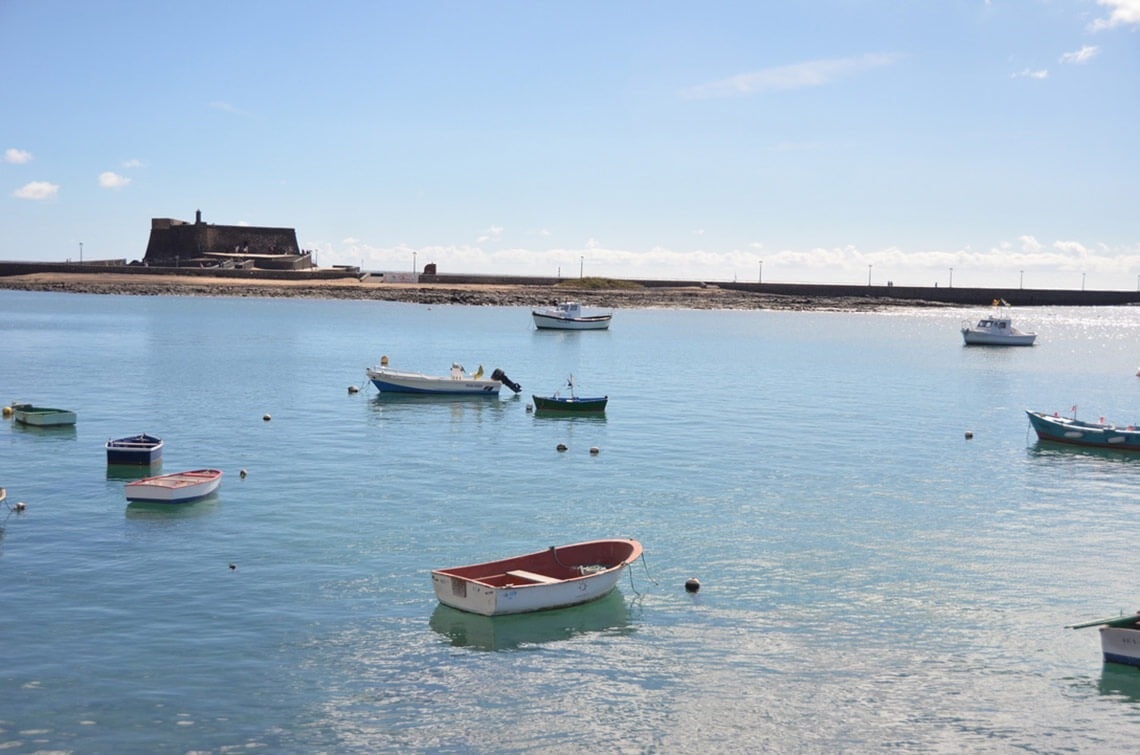 a few boats are floating in the water and one of them has the letters a on it
