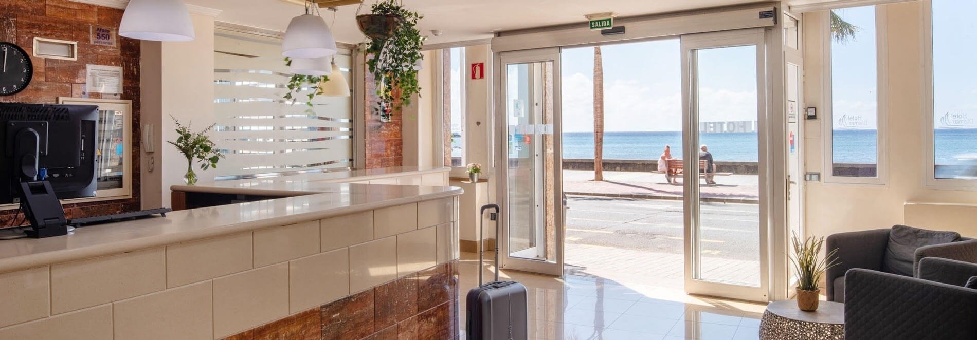 a hotel lobby with a sliding glass door leading to the ocean