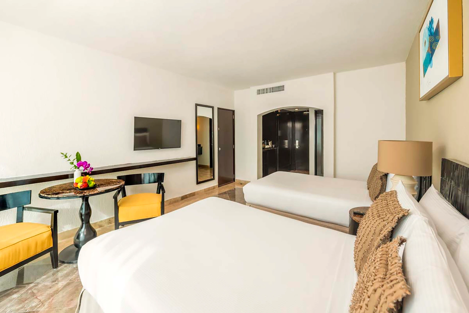 Spacious hotel room with two queen beds, a sitting area, and modern amenities, perfect for your DEMO 3.
