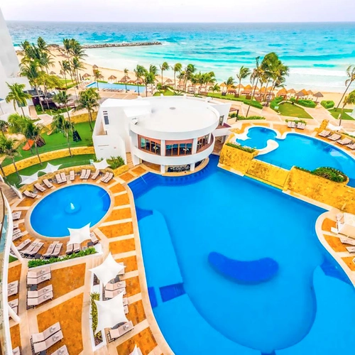 Aerial view of a luxury resort with pools, beach, and palm trees, ideal for a tropical DEMO 3.