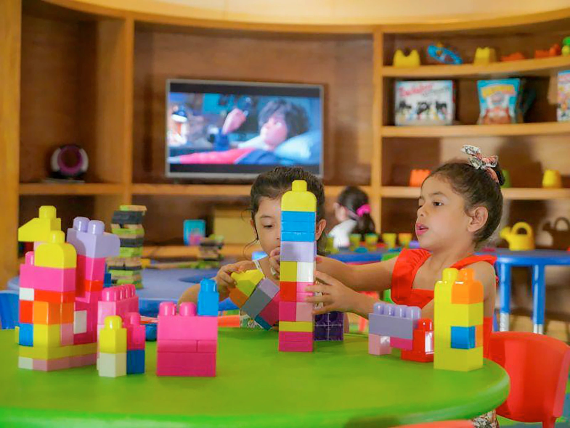 Niños jugando con bloques de construcción en un área recreativa infantil de hotel, ideal para DEMO 3.
