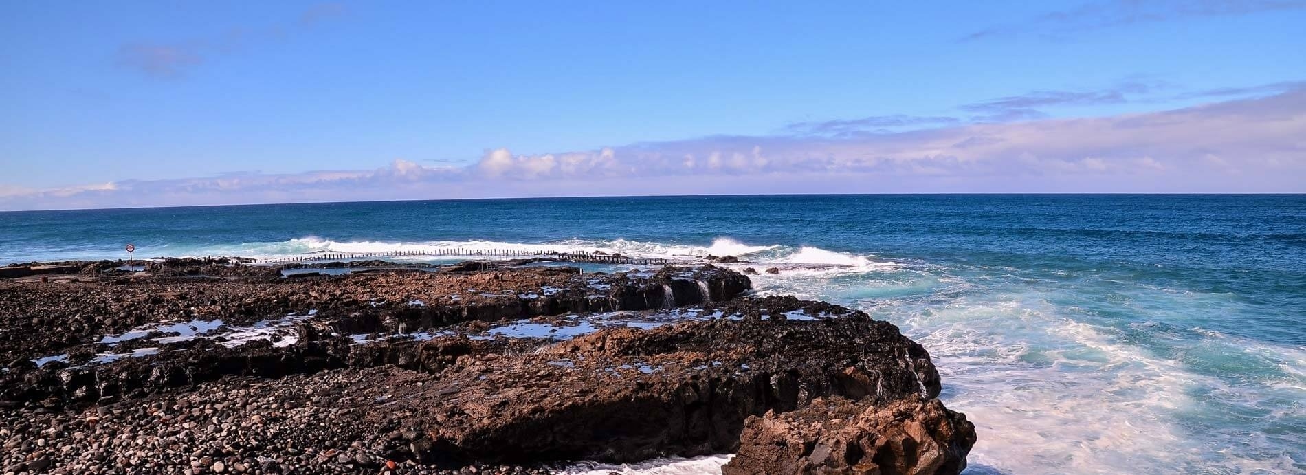 a rocky shoreline with waves crashing on the rocks