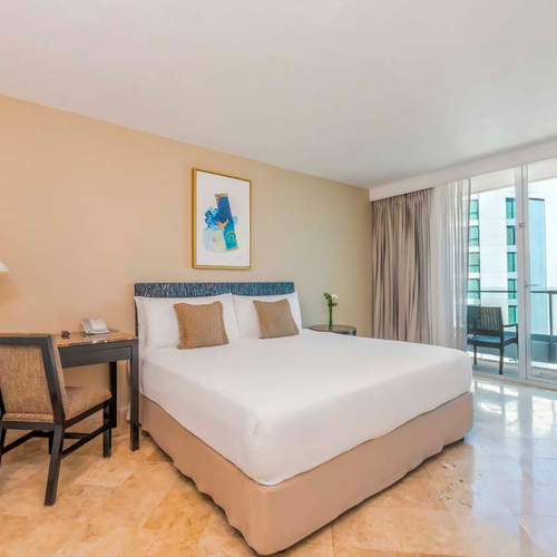 Modern hotel room with king bed, desk, and balcony view DEMO 3.