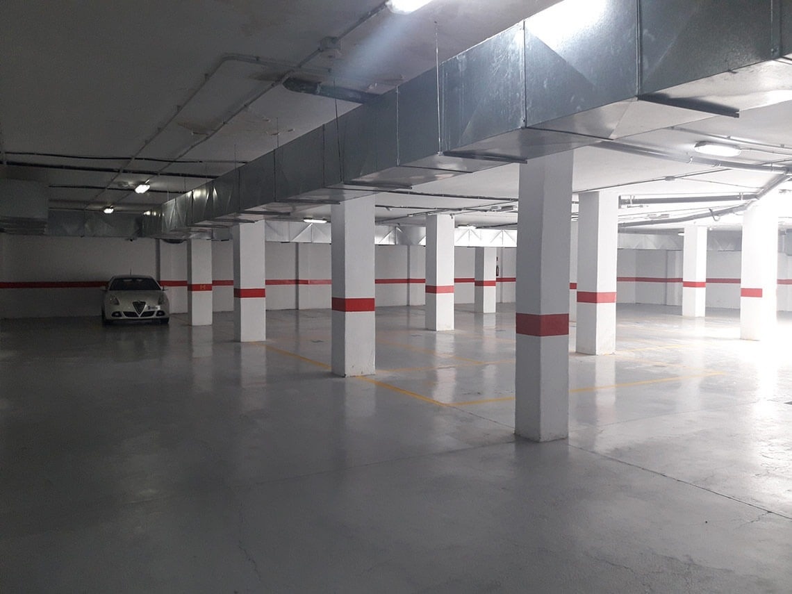 un coche blanco está estacionado en un garaje vacío