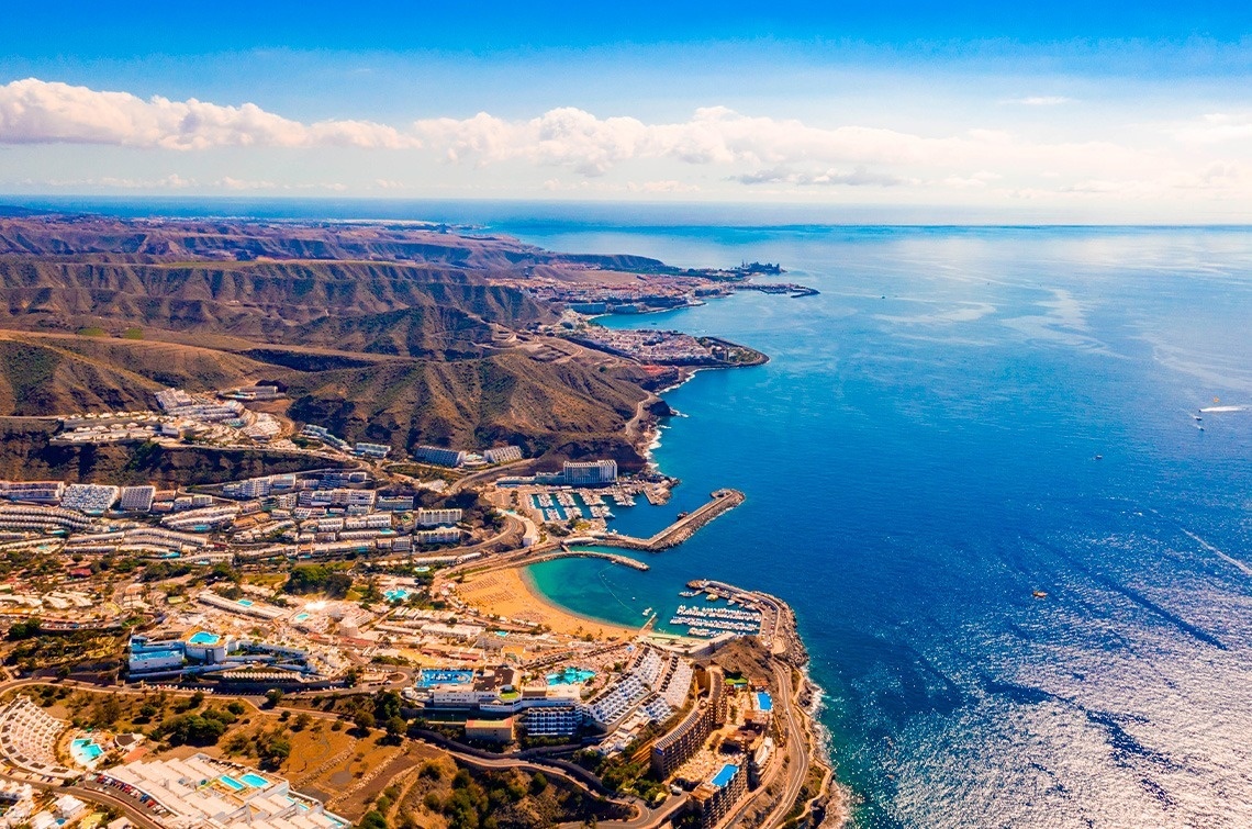 an aerial view of a large body of water with mountains in the background