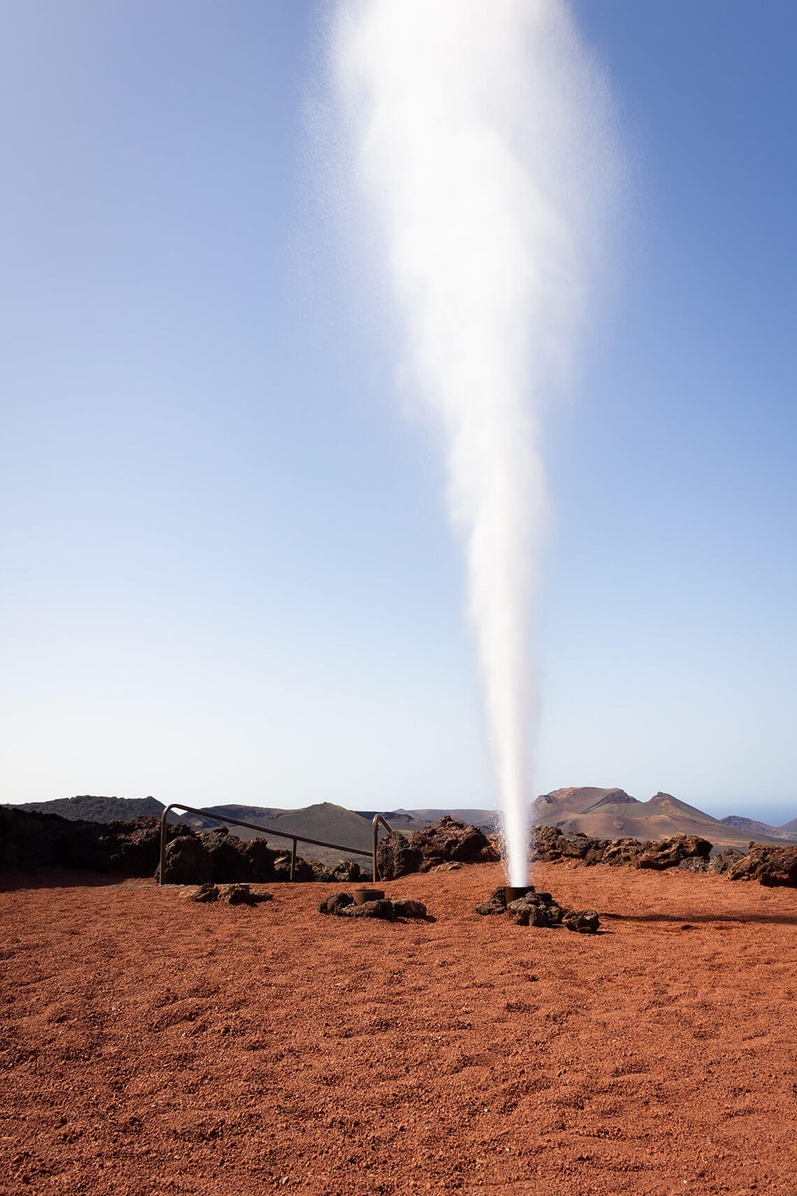 a geyser is erupting in the middle of a dirt field