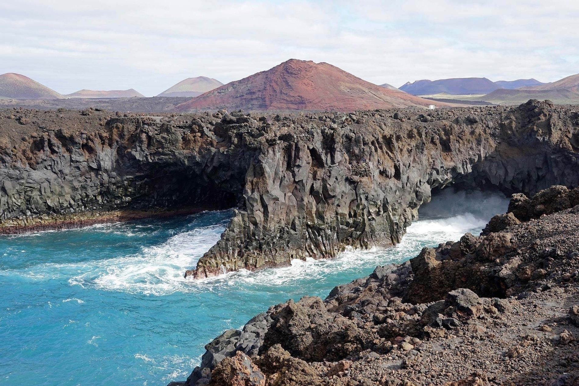 una vista aérea de un océano azul con rocas en la orilla