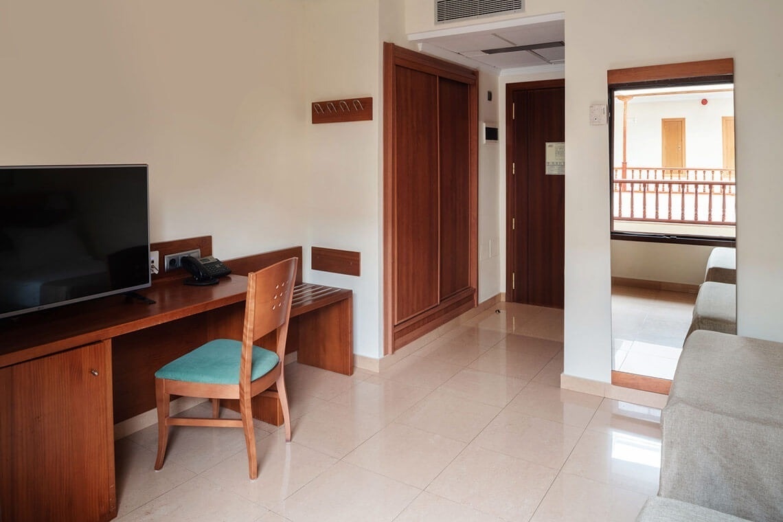a room with a desk chair and a flat screen tv
