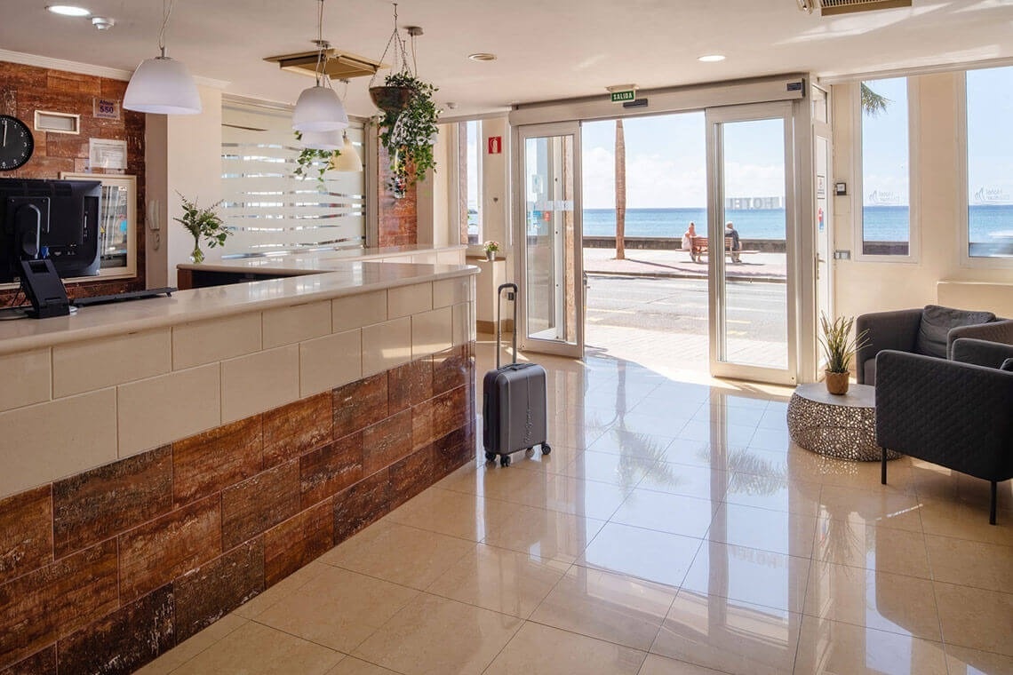 el vestíbulo de un hotel con una maleta en el mostrador