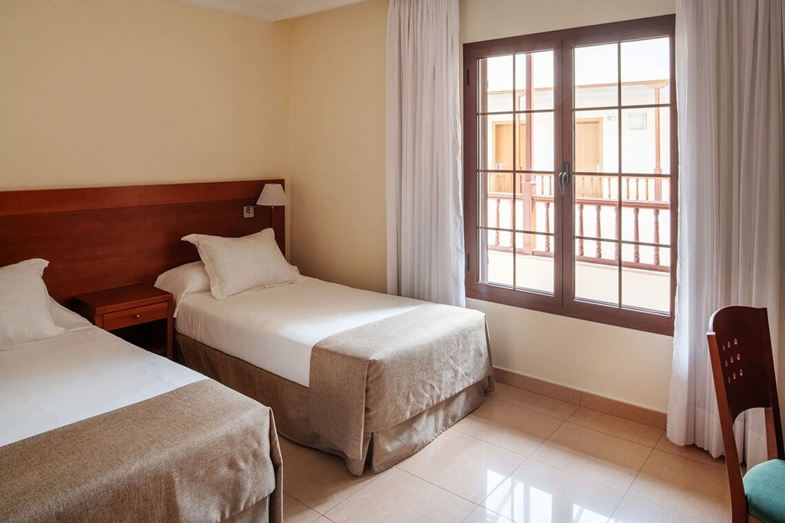 a hotel room with two beds and a large window