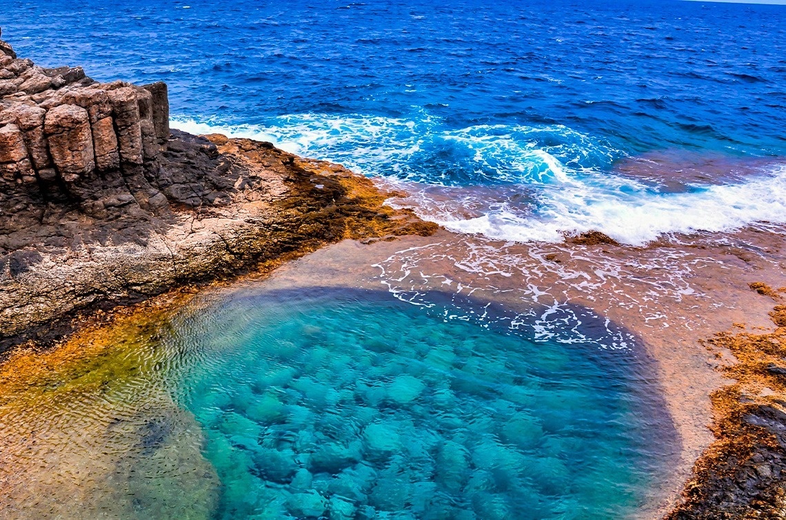 a large body of water surrounded by rocks and waves