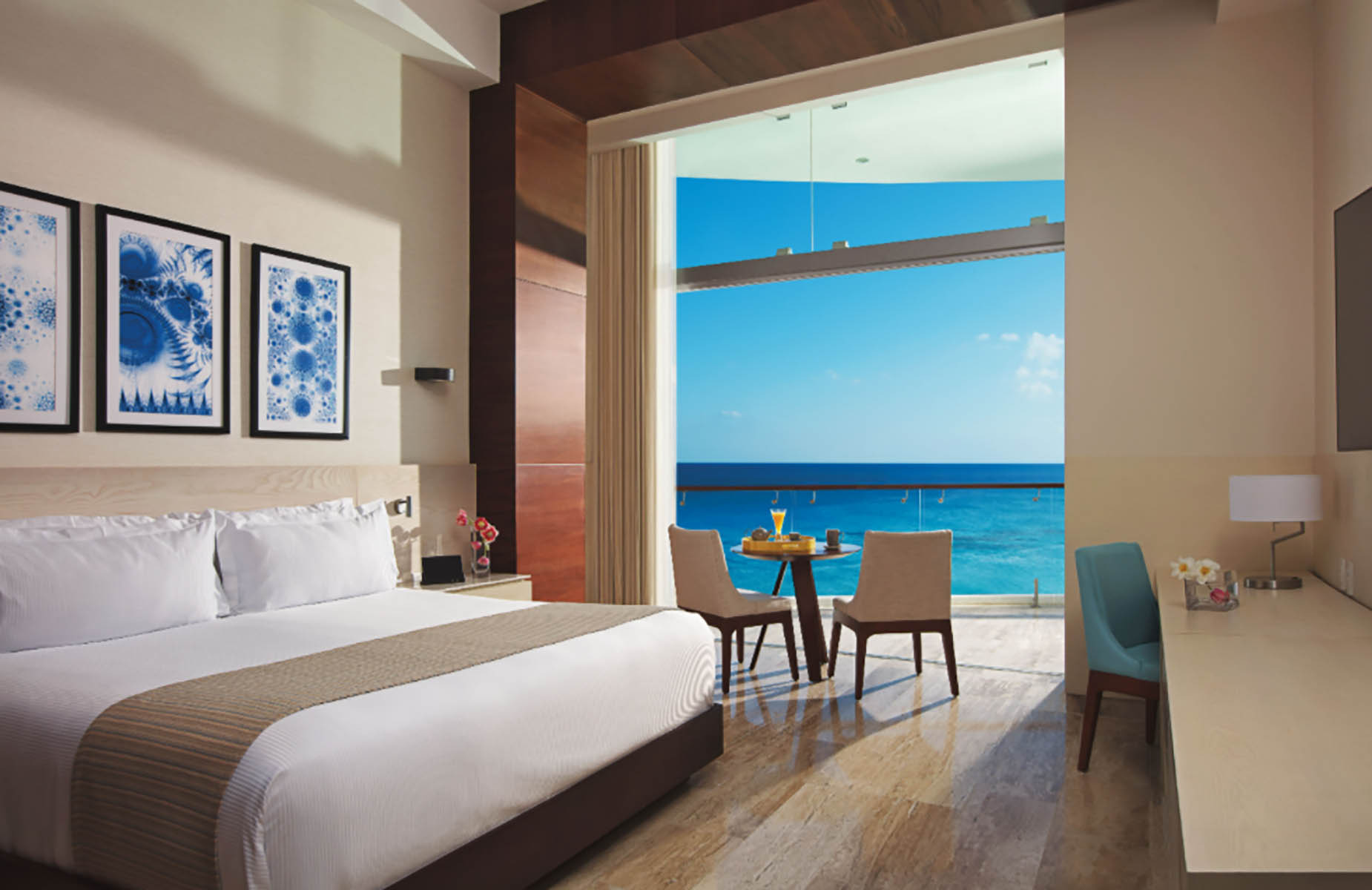 Luxurious hotel room with ocean view balcony, king bed, and desk. DEMO 3.