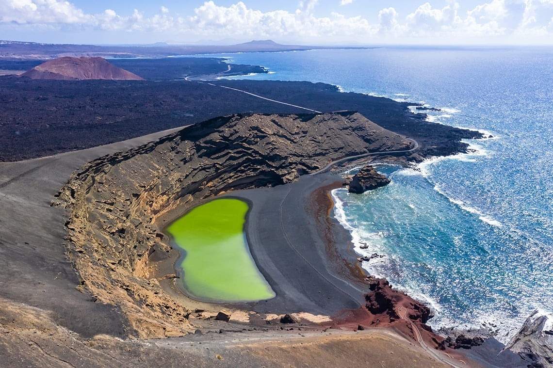 an aerial view of a green lake in the middle of the ocean