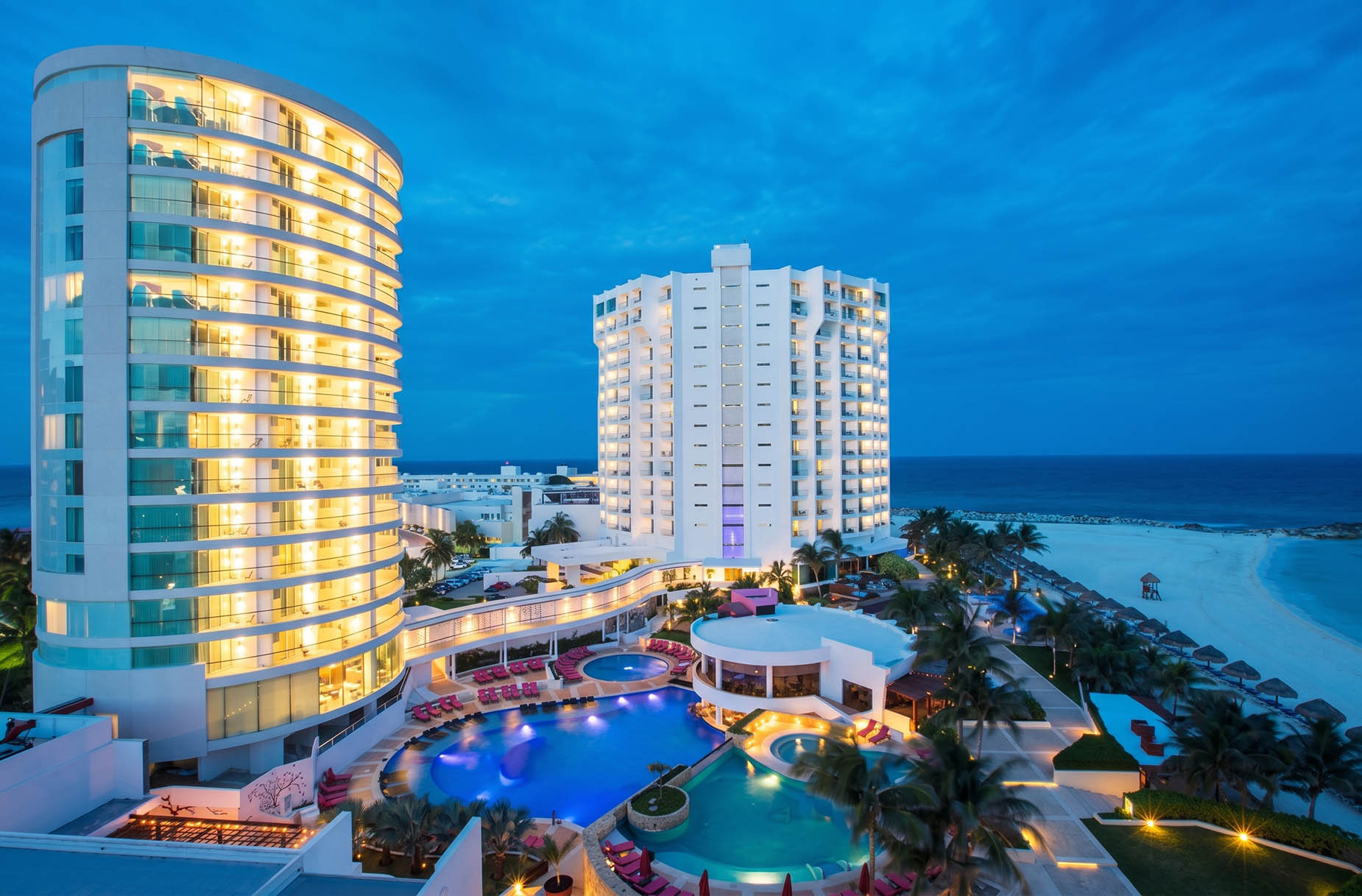 Luxury resort pool and beach at dusk, showcasing modern architecture and ocean views. DEMO 3
