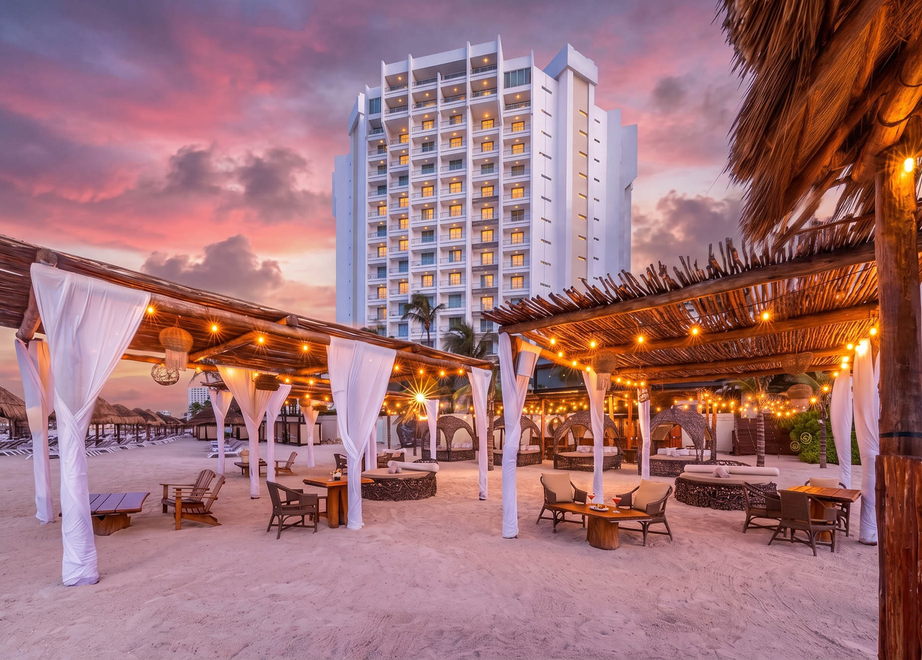 Luxury beachfront resort with cabanas, lounge chairs, and a hotel tower at sunset, perfect for DEMO 3.