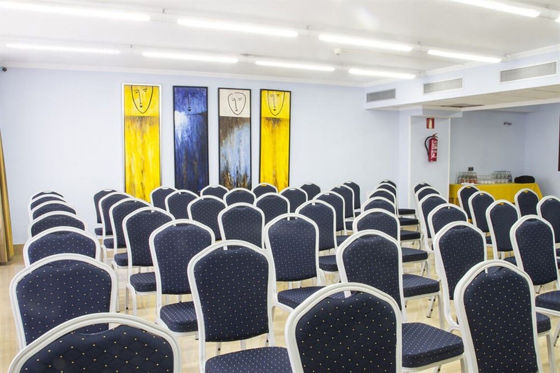 una sala de conferencias llena de sillas azules y blancas