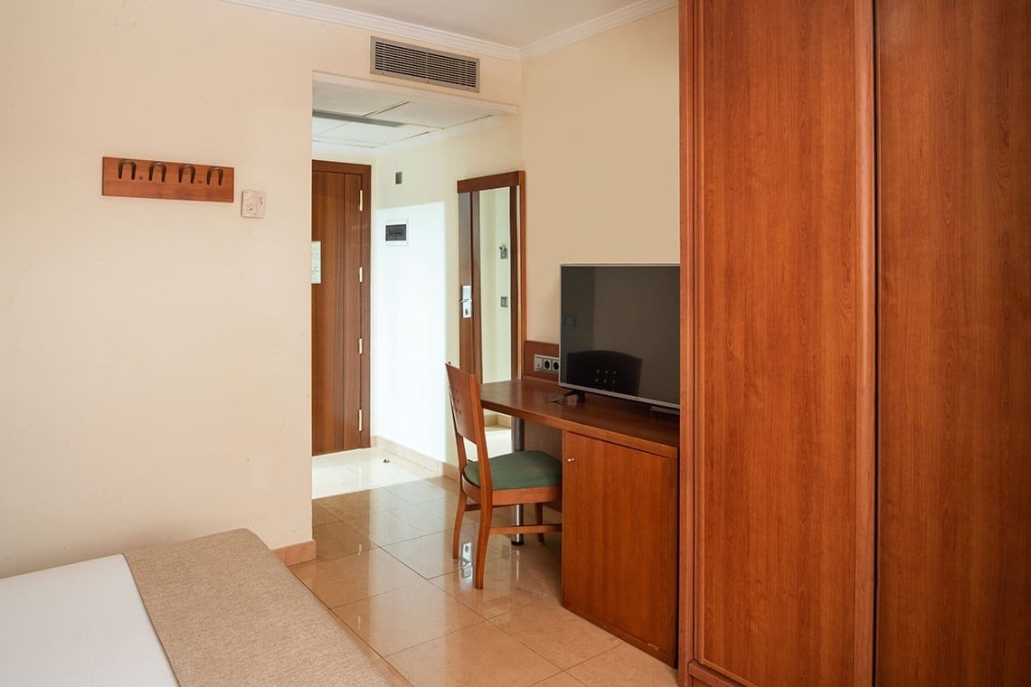 a hotel room with a desk and a flat screen tv