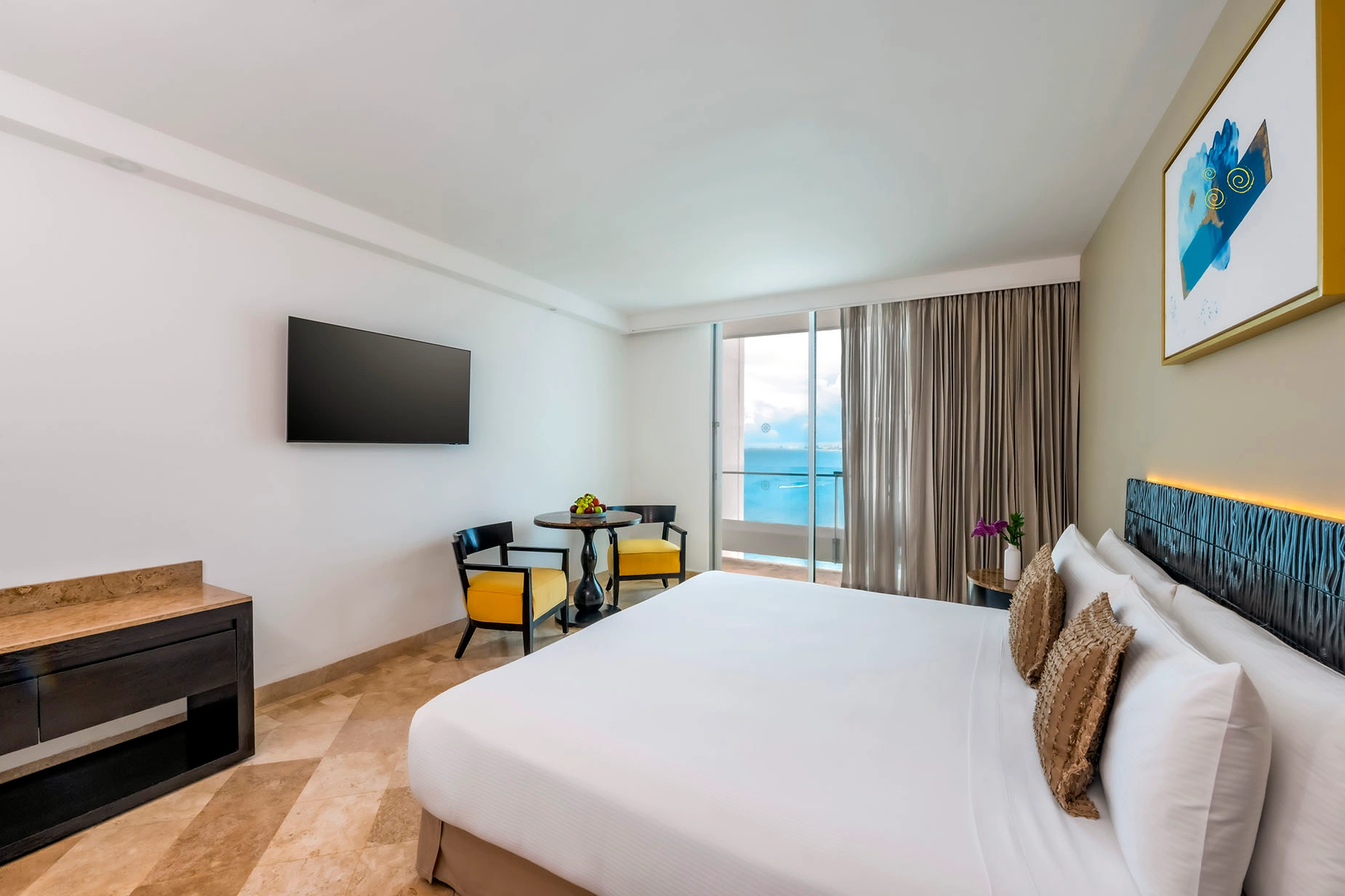 Luxury hotel room with king bed, ocean view, and seating area. DEMO 3