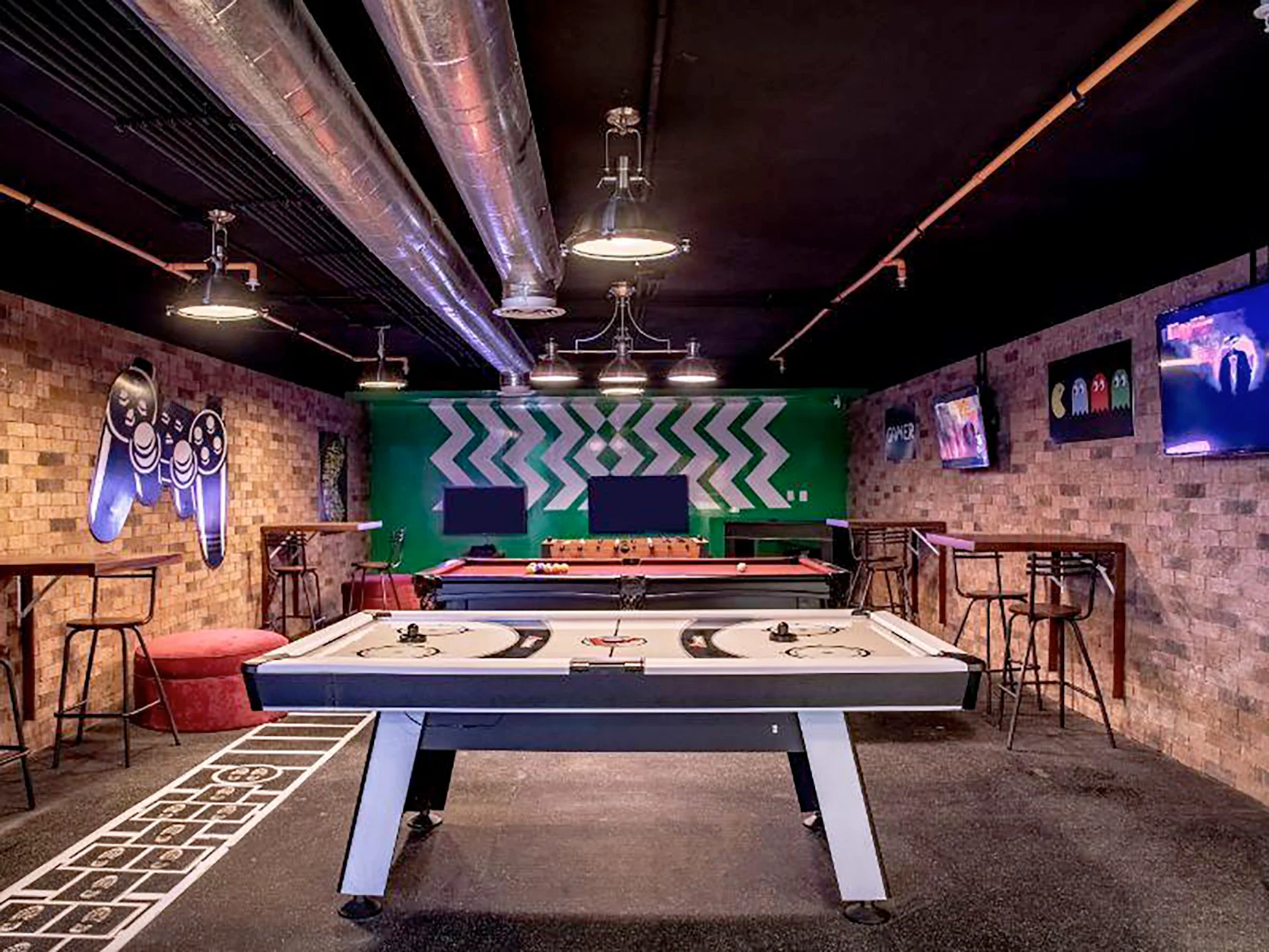 Sala de juegos para huéspedes del hotel, con mesas de billar, hockey de aire y TVs, ideal para DEMO 3.