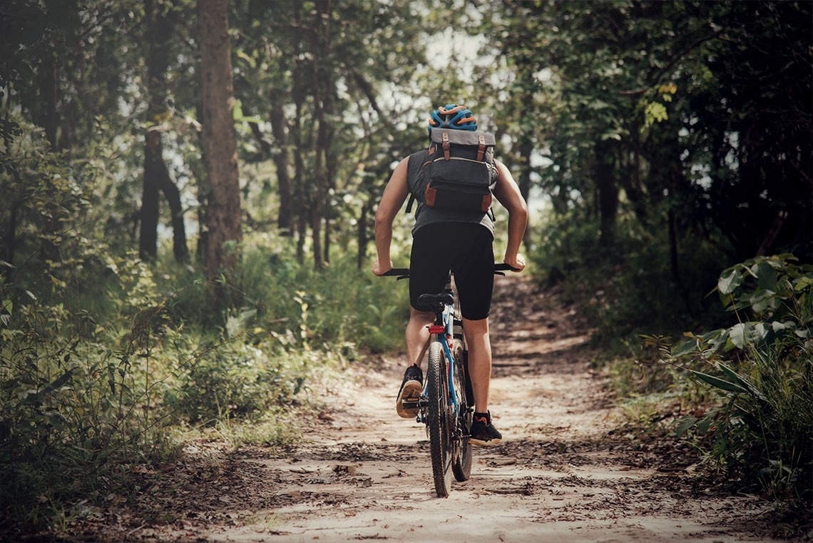 a person riding a bike down a dirt road