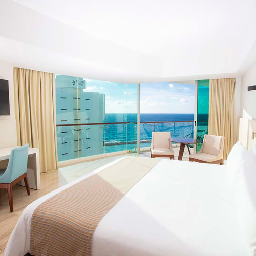 Luxury hotel room with ocean view, queen bed, desk, and balcony. DEMO 3