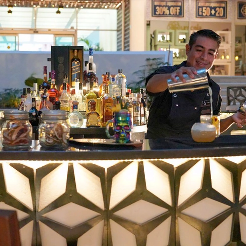 Bartender preparing a cocktail at a stylish hotel bar, showcasing a premium drinks selection. DEMO 3