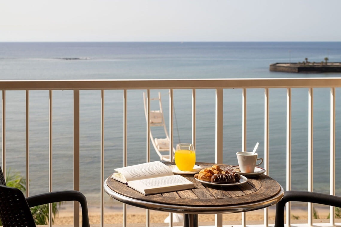 a table with a book and a glass of orange juice on it