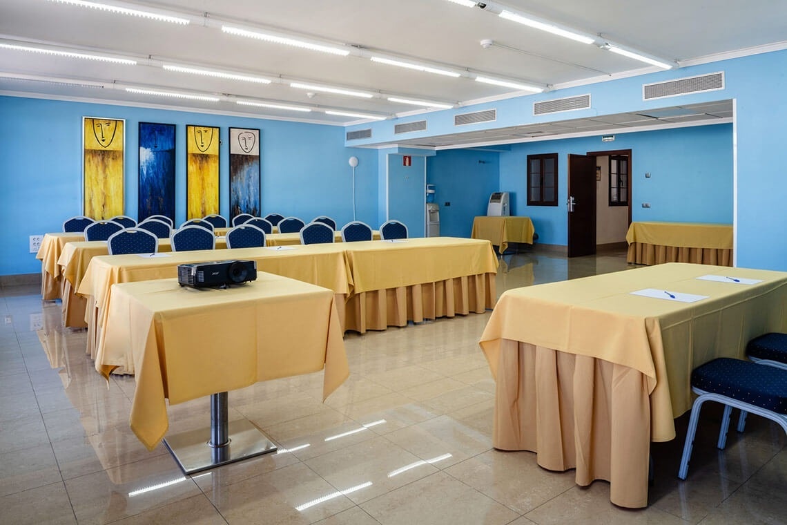 a conference room with tables and chairs and a projector