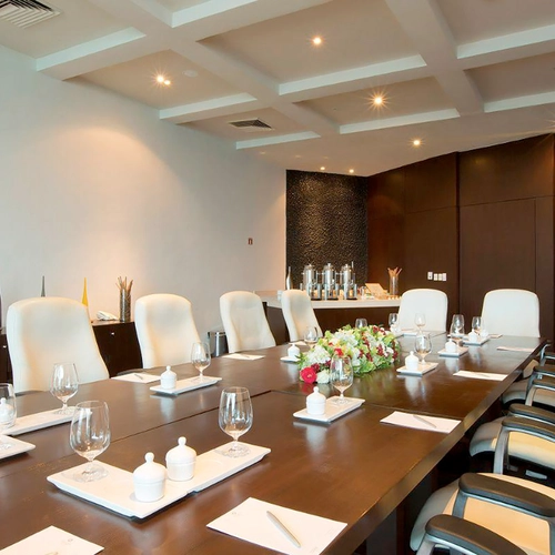Conference room with long table, chairs, and floral arrangement. Ideal for DEMO 3.
