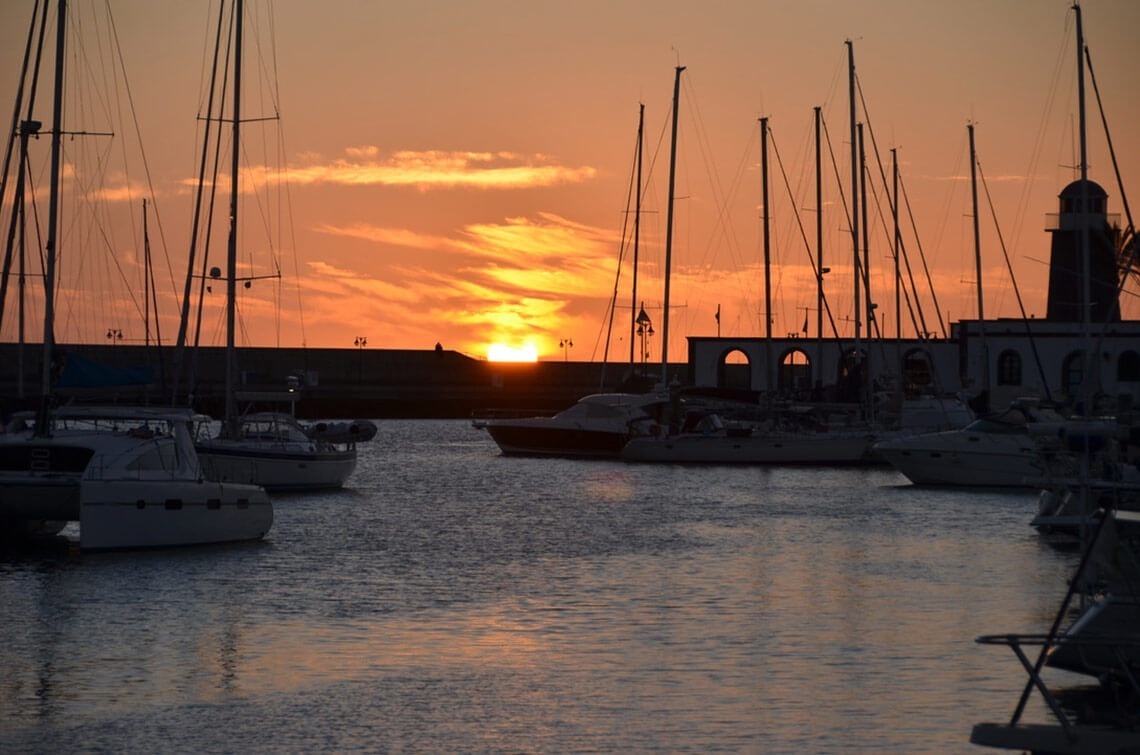 boats are docked in a harbor at sunset