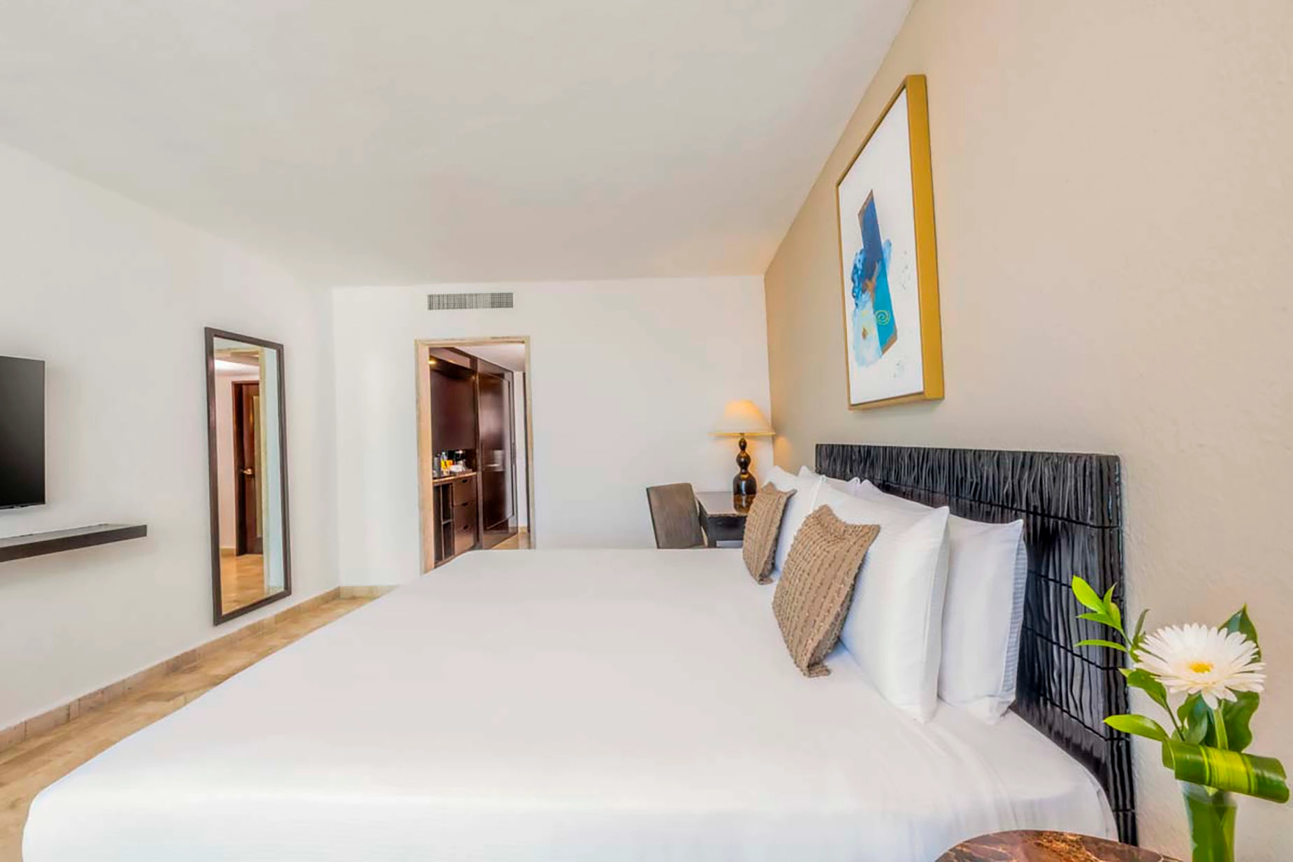 Modern hotel bedroom with king-size bed, abstract art, and a mirrored wardrobe. DEMO 3